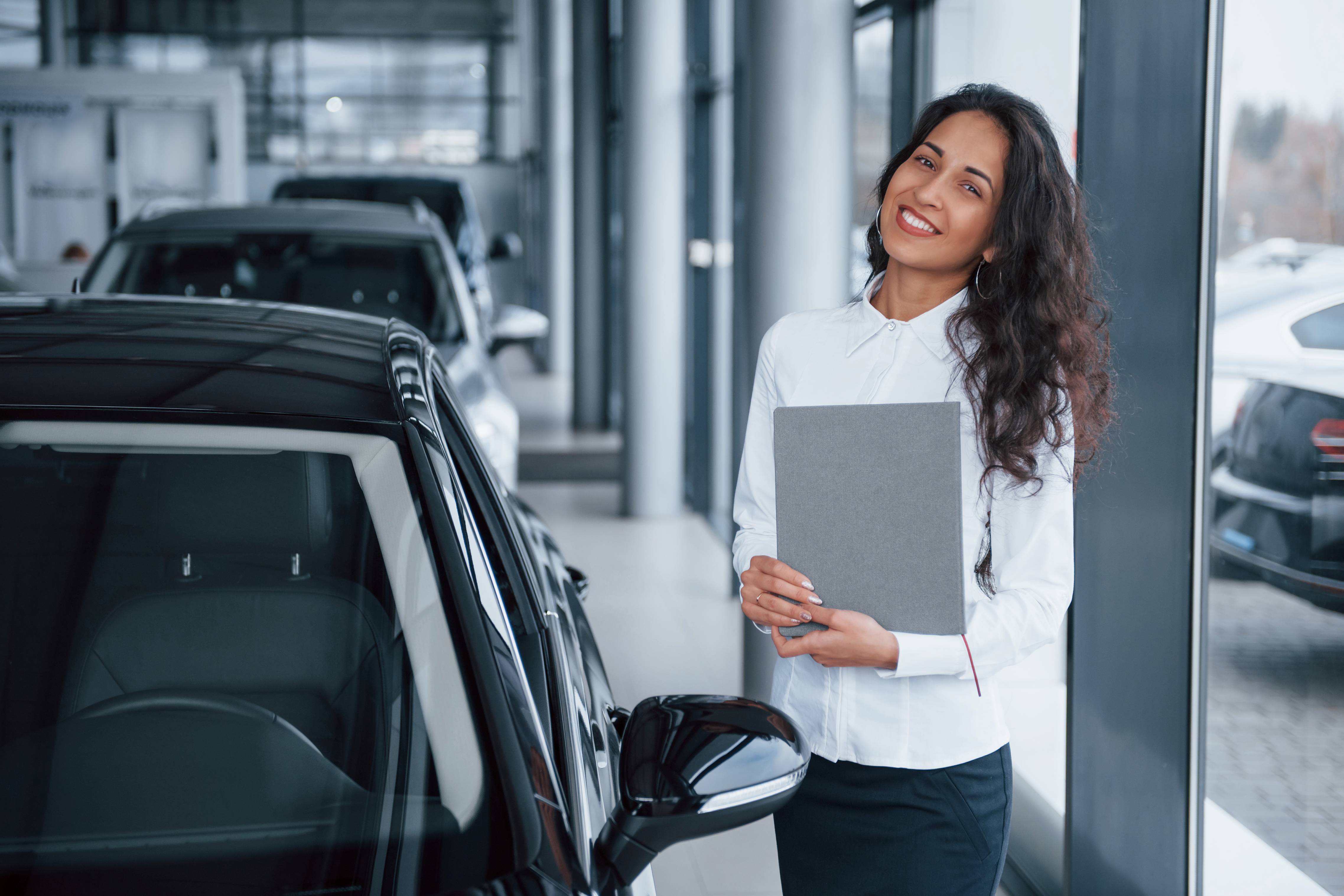 curly-haired-female-manager-stands-near-car-automobile-salon (1) curly-haired-female-manager-stands-near-car-automobile-salon (1)